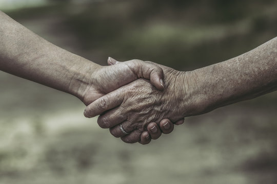 高齢女性と若い女性の握手