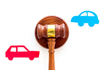 Car accident lawsuit concept. Two collided cars near judge gavel on white background top view copy...