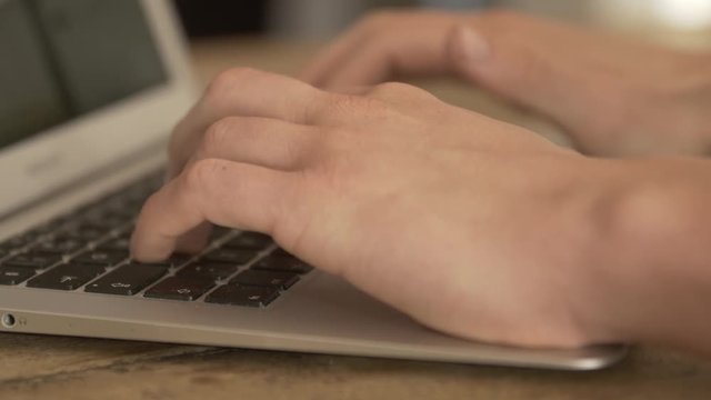 Typing on a keyboard from a laptop.