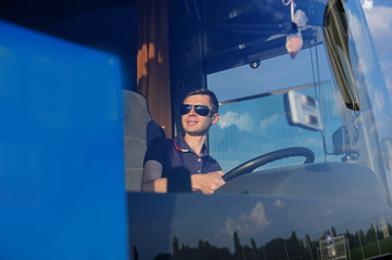 Young man at the wheel is looking away from the bus