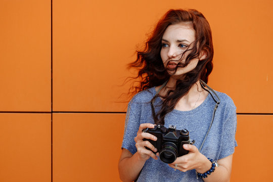 Portrait of a beautiful girl using a vintage film 35mm camera
