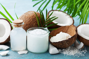 Set of natural coconut products for spa treatment, cosmetic or food ingredients decorated palm leaves. Coconut oil, water and shavings. - obrazy, fototapety, plakaty