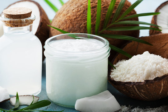 Set of organic coconut products for spa, cosmetic or food ingredients decorated palm leaves. Natural oil, water and shavings.
