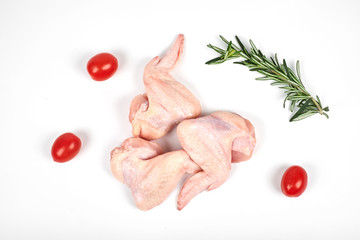 Raw chicken wings, tomatoes and rosemary isolated on white background