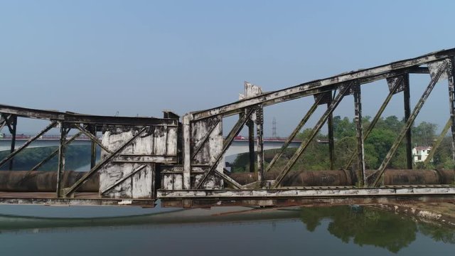 Aerial view. Drone flight along old, lengthy and rusty truss-type aqueduct over the river. 