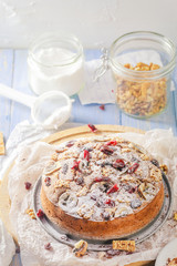 Delicious banana cake with nuts, sesame and cranberry on a wooden table