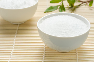 Obraz na płótnie Canvas Salt in a white bowl on bamboo background.