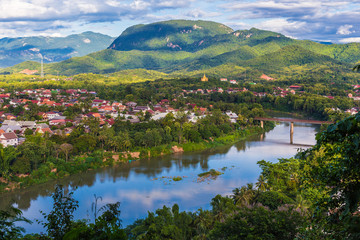 View of Luang Prabang and Nam Khan river in Laos with beautiful sunset light bathing the mountains