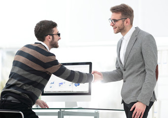 Business associates shaking hands in office