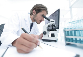 scientist makes a note of experiment in the laboratory - obrazy, fototapety, plakaty