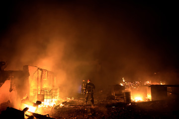 Fototapeta na wymiar Silhouette of fireman fighting bushfire at night