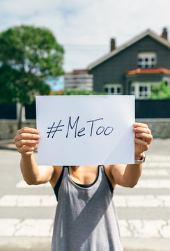Unrecognizable young woman showing poster with metoo hashtag