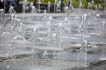 Splashing water from a fountain in the park as a background