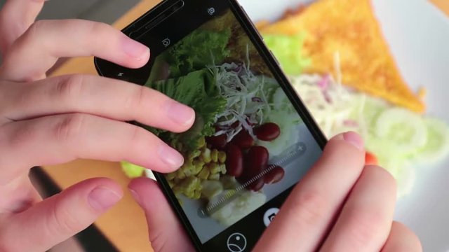 Female hands using smartphone taking photos of light breakfast