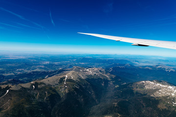 Naklejka premium Aerial view of landscape through airplane window against sky