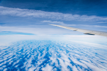 Aerial view of cloudscape through airplane window against sky
