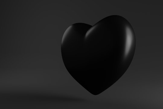 glossy black heart hanging in the air on a dark background