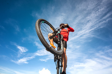 cyclise riding mountain bike over over the obstacle during the way of riding
