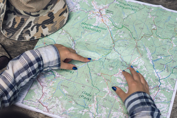 Hands woman on tourist map. Woman is planning route.