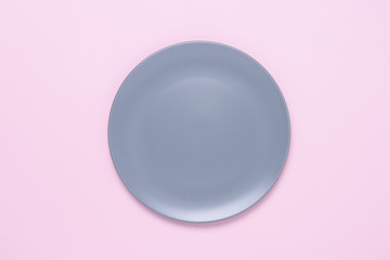 An empty round plate isolated on pink background.