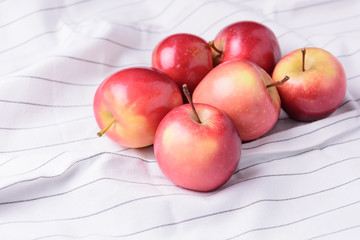 Fresh ripped red apples on table cloths.