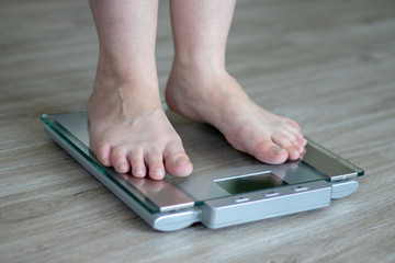 Woman standing on a scale in the bathroom