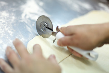Cutting a puff pastry with a pizza knife - 212045040