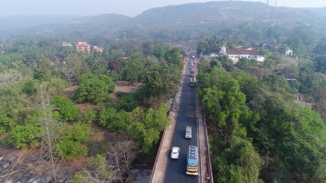 Aerial view. Flying over the bridge, active traffic on a large concrete bridge across the river. Shooting with a drone.