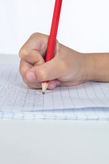 Children's hands holding pencil and doing homework