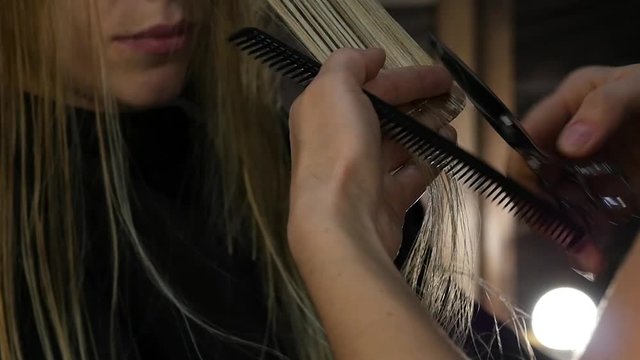 Female hairdresser do haircut closeup. Hair clipper. Hairstyle haircare and restoration. Hairdresser trimming hair with scissors