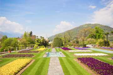 Fototapeta premium Spring landscape with colorful flowers, Beautiful view of amazing tropical scenery with bright day blue sky and clouds in spring nature background, Landscape Gardens of Villa Taranto, Lago Maggiore.