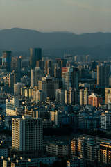 The city is in sunset rays against the backdrop of the mountains. Hainan. China