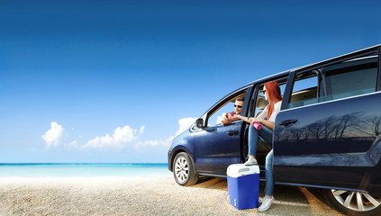 Fototapeta na wymiar Summer trip on beach. Big blue car with two people. Free space for your text. 