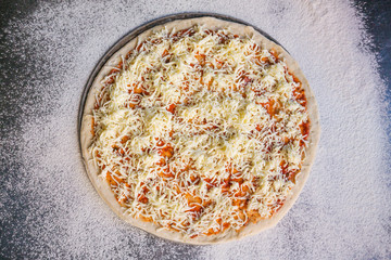 prepared pizza with ingredients