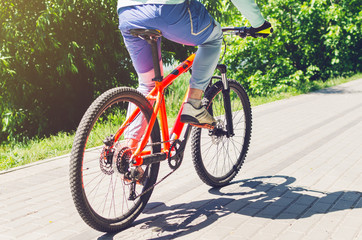 Fototapeta na wymiar Cyclist on an orange bike riding a bicycle path