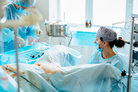 Female doctors performing gynecological operation at the hospital healthcare medicine gynecology treatment curing help assistance experience. Real scene