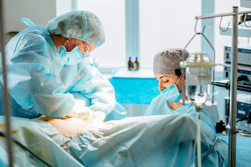Process of Gynecological surgery operation. Female doctors performing gynecological operation at...