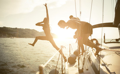 Silhouettes of friends jumping from the boat