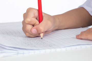 Children's hands holding pencil and doing homework