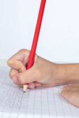 Children's hands holding pencil and doing homework