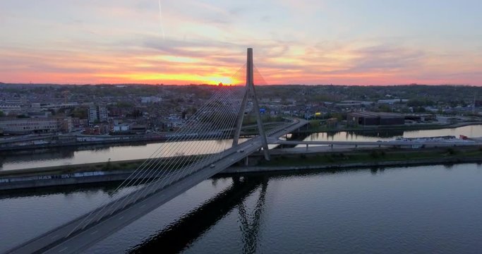 Aerial view of steel cable bridge crossing in Belgium. Road in perspective. European bridge over a river at sunset.