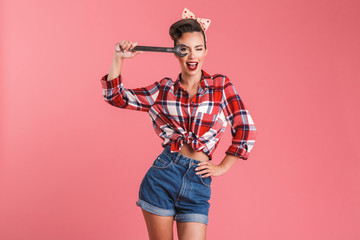 Amazing young pin-up woman holding wrench.