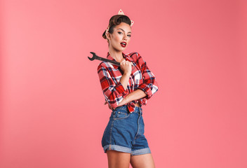 Amazing young pin-up woman holding wrench.