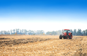 Obraz premium Modern red tractor in the field.