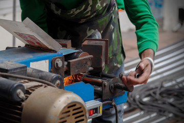 Worker Use Belt Sander to Scrub a Thick Stainless Steel Tube in a Construction Work Site.