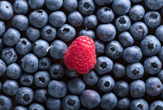  Ripe and juicy fresh blueberries and raspberry .