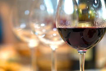 Red Wine in front of beautiful blurred wedding background.