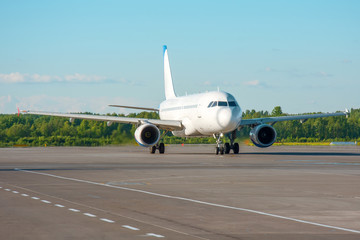 Airplane taxiing on the apron of the airport on the asphalt is visible marking.