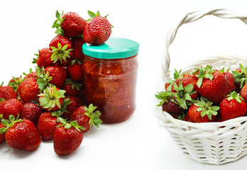 Red strawberries in the basket and on the table isolated on white background. 