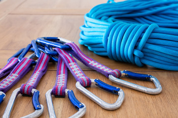 quick draw and climbing rope on a wood surface